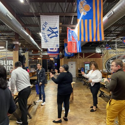 Group of SMLR Alumni gathered talking at Bury The Hatchet Axe Throwing